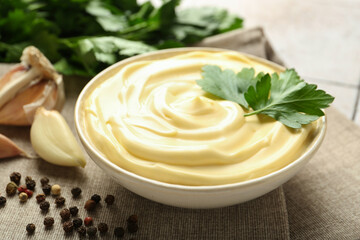 Delicious mayonnaise sauce with parsley in bowl on table, closeup