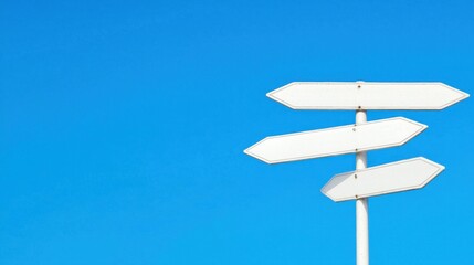 Empty Directional Signs Against a Clear Blue Sky Background