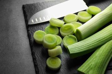 Chopped leeks and knife on grey table, closeup