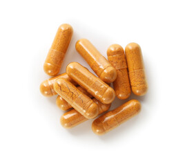 Many turmeric capsules isolated on white, top view