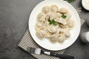 Delicious dumplings served on grey table, flat lay