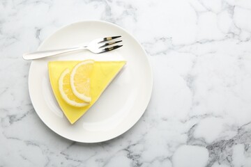 Piece of tasty lemon cheesecake and fork on white marble table, top view. Space for text