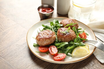 Delicious patties with greens, tomatoes, ketchup and drink on wooden table, closeup. Space for text