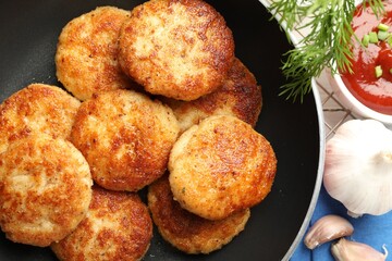 Delicious patties, spices and ketchup on table, flat lay