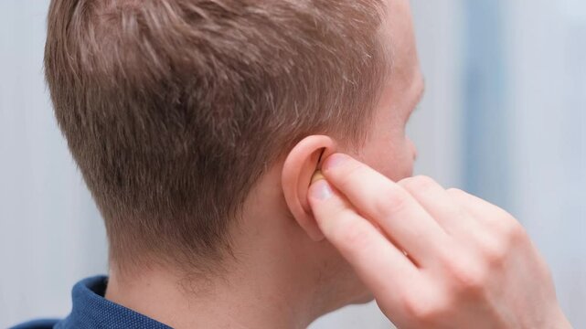 A man puts earplugs in his ear