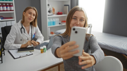 Fototapeta premium Woman taking selfie with doctor in clinic room showcasing a friendly medical environment with professional care and patient interaction indoors.