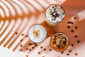 Ice coffee in a tall glasses with coffee beans around.