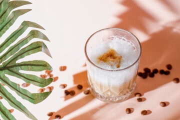 Ice coffee in a tall glasses with coffee beans around.