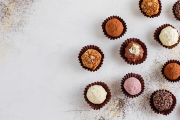 Homemade chocolate truffles with dark chocolate ganache covered with pink powder, waffle crumbles, gold flakes, coconut and nuts