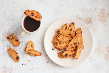 Italian raisin almond biscotti and glass of milk on light background.