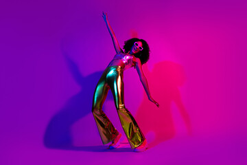 Vibrant young woman posing in a glowing neon-lit scene showcasing retro disco style with gold...