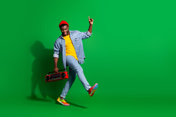 Stylish young man holding a retro boombox, enjoying vibrant energy with a trendy casual outfit and joyful demeanor