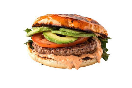 A gourmet burger with a perfectly seared patty, avocado slices, and spicy mayo, topped with a fresh tomato and served on a soft brioche bun