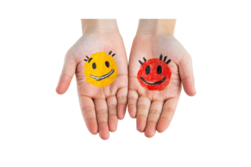 A pair of hands with vibrant smiley faces drawn on the palms, showcasing an assortment of emotive expressions from happiness to playfulness.