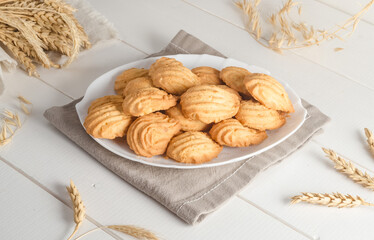 Shortbread cookies in a plate on a white wooden background