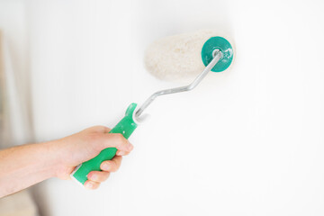 Hand whitewashing a wall with roller tool