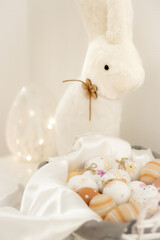 Easter eggs in a basket with a white bunny, creating a light and festive Easter composition, perfect for holiday decorations and spring celebrations.