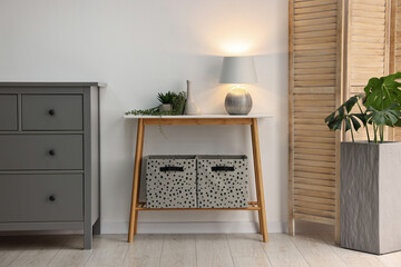 Stylish room interior with console table near white wall