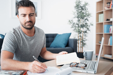 Fototapeta premium Man working from home using computer and internet connection