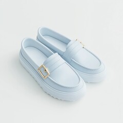 A brand-new pastel blue loafer with a metallic gold buckle, sleek stitching, and a soft insole, isolated on a white background.