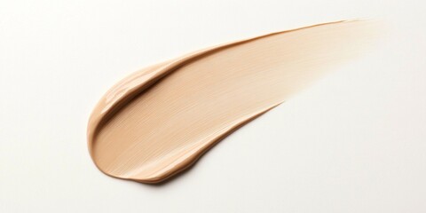 Cosmetic Swatch: A smear of light foundation or concealer. Showing smooth texture.