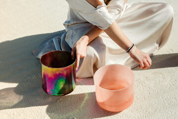 woman with sound bowls sitting in desert