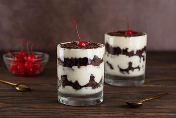 Dessert cherry Black forest or Schwarzwald cupcakes in a glasses on a wooden table. Vegan dessert.