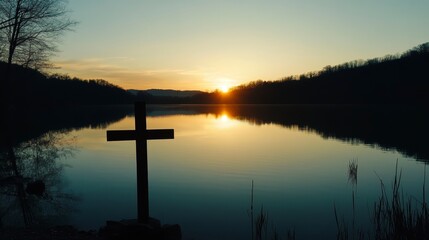 Wooden cross at sunrise over tranquil lake