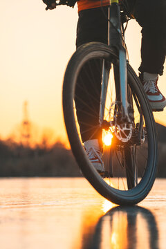 A man in gear rides a bicycle on the ice of a frozen lake
