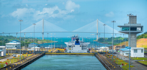 Fototapeta premium Control towers and news locks of the Panama Canal at Agua Clara on the Atlantic/Caribbean side, Colón, Panama. The Atlantic Birdge can be seen in the background.