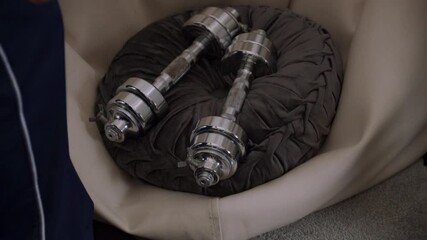 Man chooses dumbbells over a book, symbolizing overcoming laziness and prioritizing fitness.