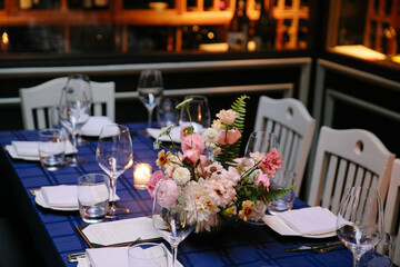 Elegant table setting with a floral centerpiece in a cozy restaurant during an evening gathering