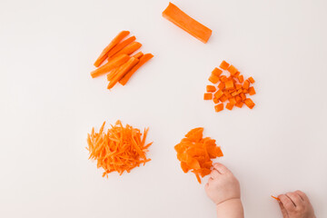 Different ways of cutting a carrot on a white background: cubes, sticks, grated shreds, and slices....