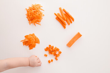Different ways of cutting a carrot on a white background: cubes, sticks, grated shreds, and slices....