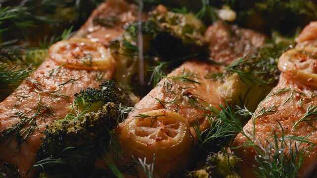 Baked salmon fillets with broccoli sprinkled with lemon juice, close-up view
