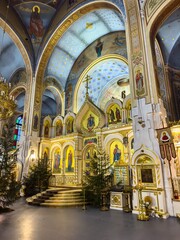 The stunning interior of an Orthodox church adorned with a golden iconostasis, intricate frescoes,...