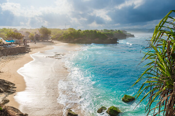 Paradise beach with ocean and cloudy sky with sun rays in Lembongan island