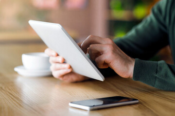 Cropped of entrepreneur using modern digital tablet while spending time at cafe
