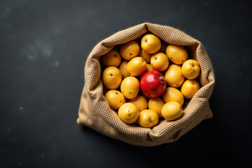 Overhead shot of a burlap sack filled with yellow fruits and one red fruit.