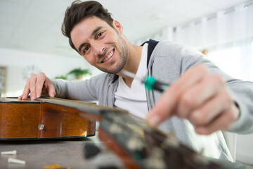 young man changing guitar strings