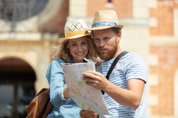 picture showing young couple sightseeing with map