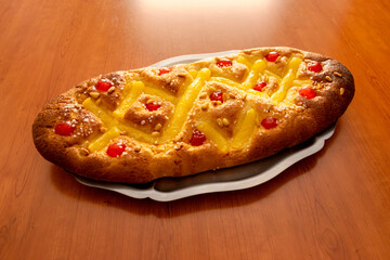 "Coca de Sant Joan" with cream, candied cherries and pine nuts, a festive Catalan sweet typical of the Saint John's Eve celebration