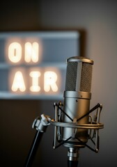 Professional microphone in front of an illuminated ON AIR sign