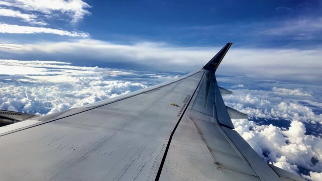 Avi&atilde;o comercial em meio a muitas nuvens e c&eacute;u azul em ponto de vista do passageiro sentado na janela na &aacute;rea da asa. Regi&atilde;o da cidade de Vit&oacute;ria em Espirito Santo, Brasil. 