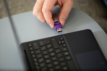 woman hand plugging a pendrive on a laptop