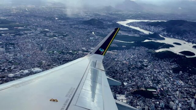 Avi&atilde;o comercial em meio a muitas nuvens e c&eacute;u azul em ponto de vista do passageiro sentado na janela na &aacute;rea da asa. Regi&atilde;o da cidade de Vit&oacute;ria em Espirito Santo, Brasil. 