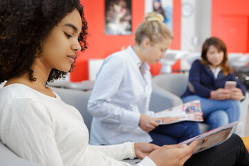 woman reading a magazine while waiting at a salon
