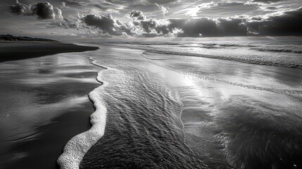 Monochrome beach photograph capturing the rhythm of incoming waves.