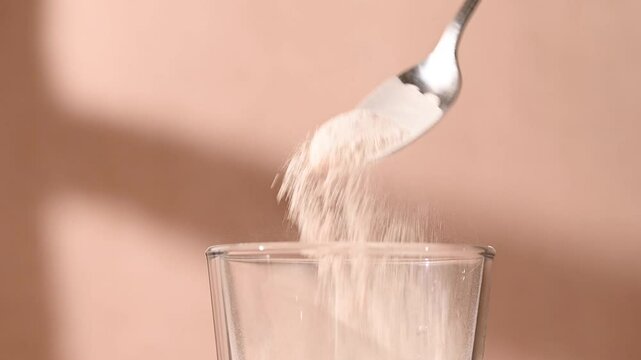 Protein powder, collagen powder pouring in a glass. Food supplement, fitness sport, health and nutrition.