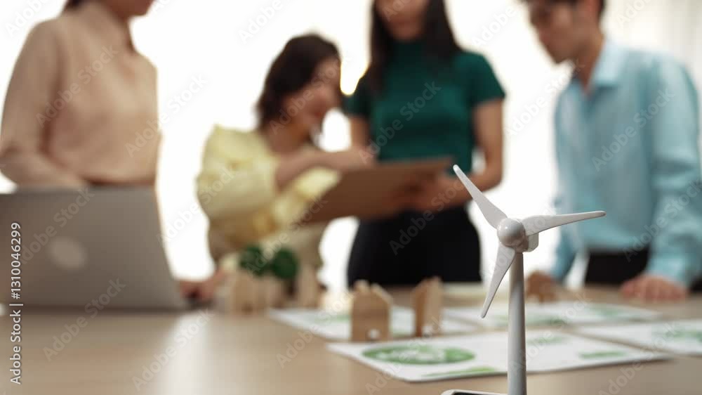Poster windmill model represented using green energy and wooden block symbolized eco house was on table in 